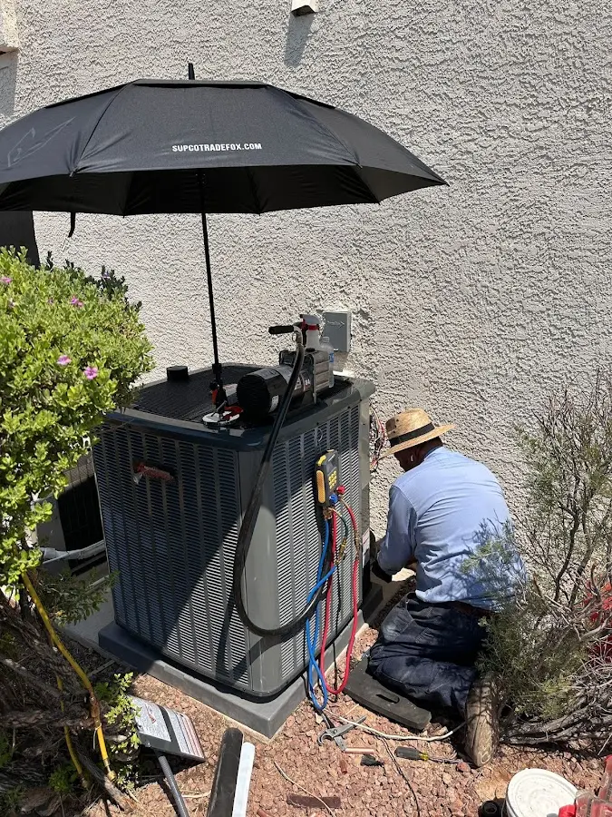 HVAC technician performing outdoor AC maintenance in Withamsville